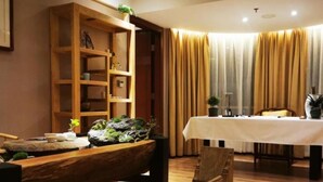 A room with a wooden bench, a dining table with a white tablecloth, and a bookshelf with various items. - Vyluk Hotel Renmin 3rd Road Qingyuan (Qingyuan)
