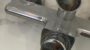 Un robinet chromé portant l’inscription « WIN WIN HOTEL » sur un comptoir en marbre.