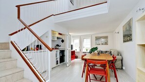 Eine Treppe führt zu einem Essbereich mit Tisch und Stühlen.