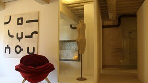 Ein Zimmer mit einem roten Sessel, einer Skulptur und einer Wand mit abstrakter Kunst.