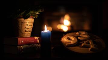 A candle, a potted plant, and wooden shapes on a table.