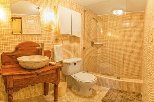 Bathroom features a classic design with a vanity, sink, toilet, and glass-enclosed shower.