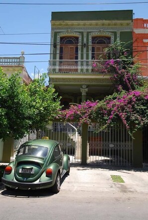 Classic car parked in front of a two-story building with a charming balcony.