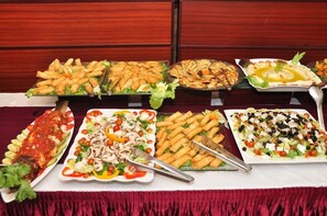 A buffet table with various dishes including fish, salads, and appetizers. - Queensgate Continental Hotel and Suites (Port Harcourt)
