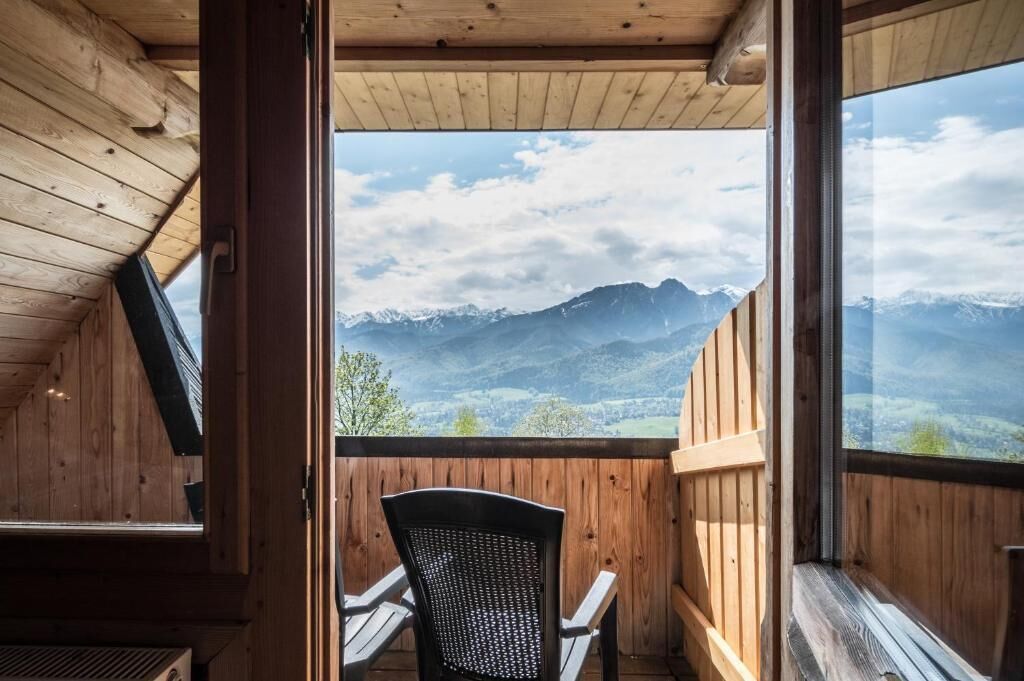 Een houten balkon met uitzicht op bergen.