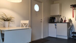 A compact kitchen with a white refrigerator, a coffee maker, and a microwave. - Södersens Golf Lodge (Billesholm)