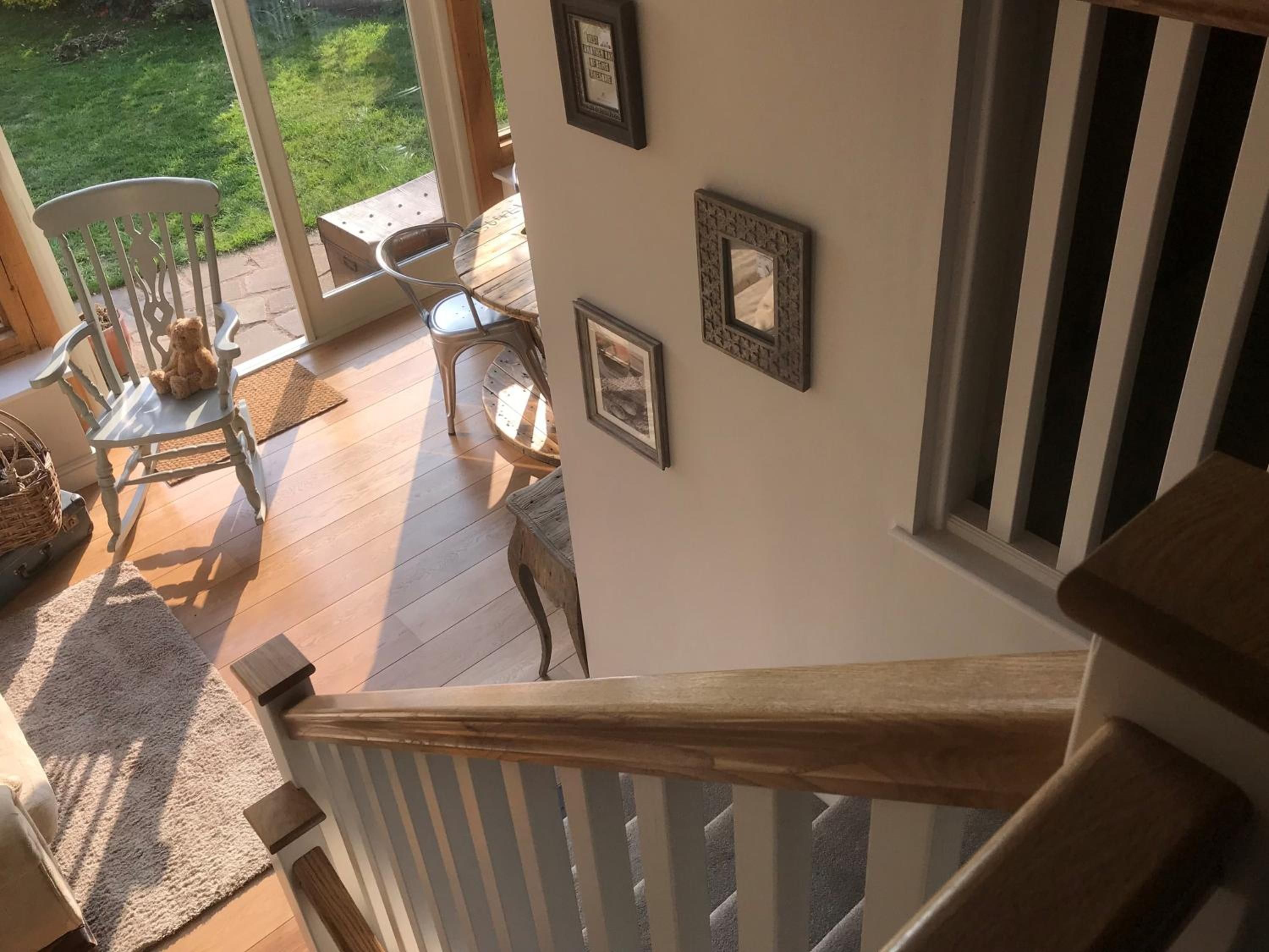 A wooden staircase with a railing leading to a deck area.