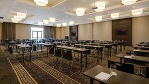 A conference room with multiple tables and chairs, large windows, and modern lighting fixtures. - Brighams Suites (Lagos)