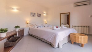Een slaapkamer met een groot bed, nachtkastjes, een spiegel en een radiator.
