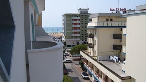 Un hotel con varios pisos, balcones y vista a la playa.