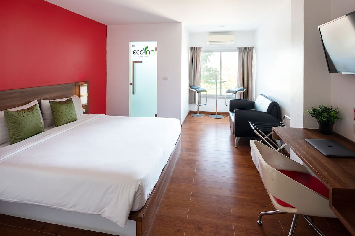 Une chambre d’hôtel équipée d’un lit, d’un bureau, de chaises et d’une télévision.