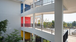 A multi-level building with balconies and railings. - Eco Inn Prime Mae Sot (Mae Sot)