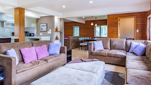 A modern living room with a brown sofa set, a dining area, and a kitchen in the background. - Cisco Moon (Kutchan)