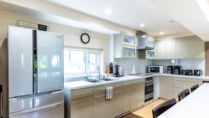 A modern kitchen with a refrigerator, microwave, and coffee maker. - Cisco Moon (Kutchan)