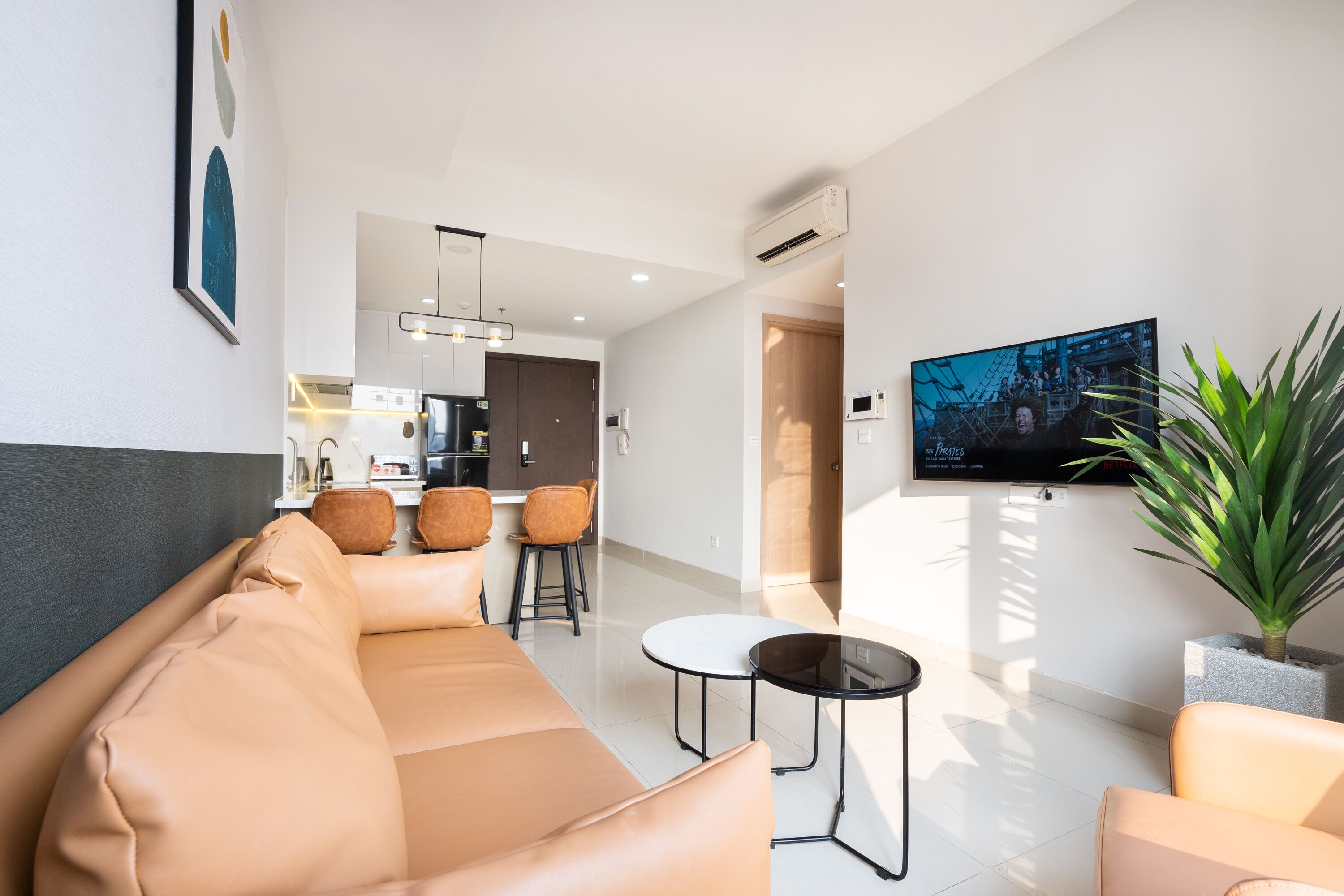 Un salon moderne avec un canapé, une table basse et un téléviseur fixé au mur.