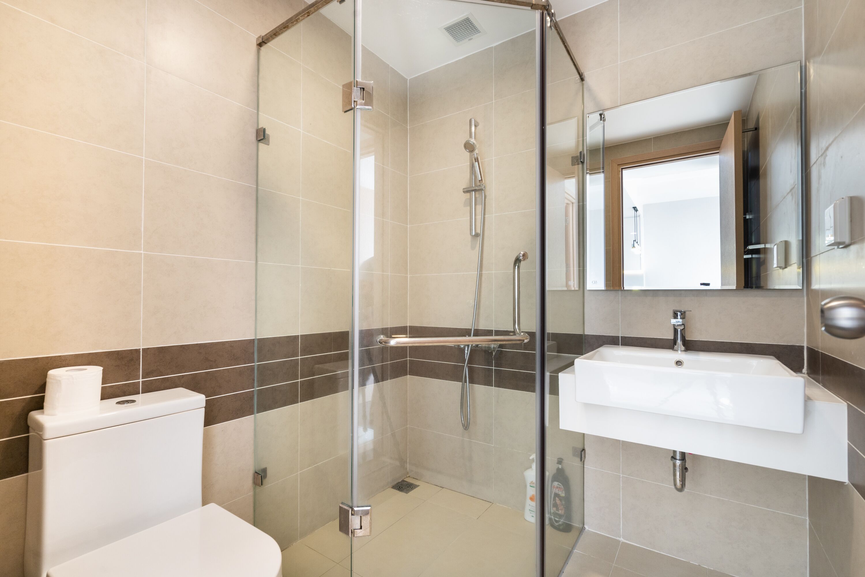 Un bagno moderno con doccia vetrata, lavandino bianco e water.