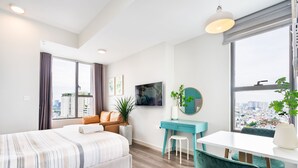 Een moderne hotelkamer met een groot bed, een bureau en uitzicht op de stad.