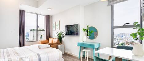 Habitación de hotel moderna con una cama grande, un escritorio y vistas a la ciudad.