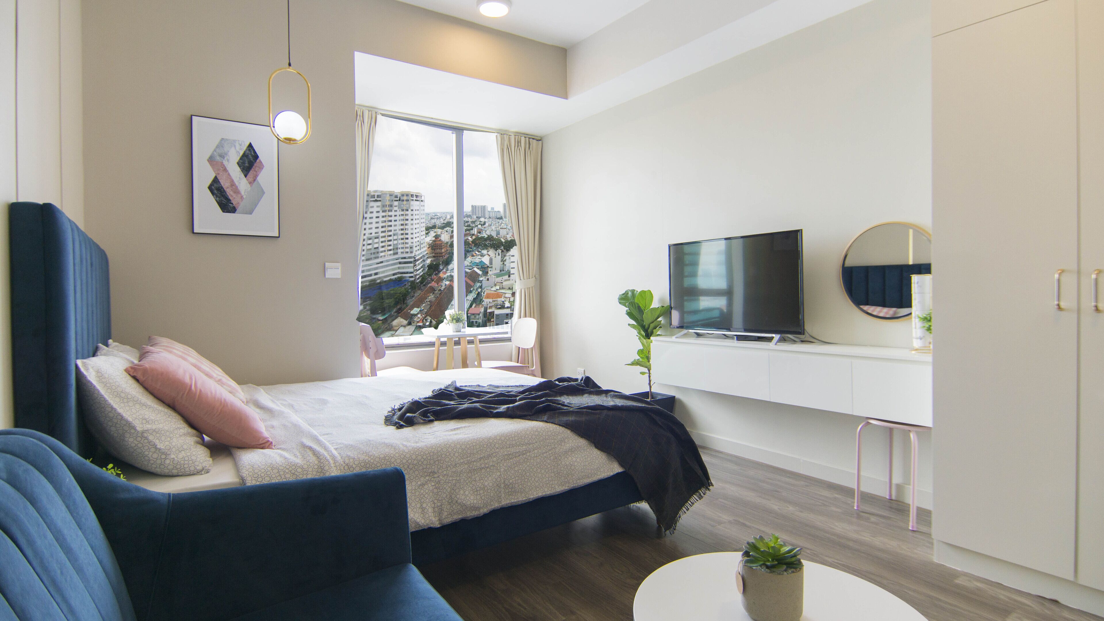 Une chambre d’hôtel moderne équipée d’un lit, d’un canapé, d’une télévision et offrant une vue sur la ville.