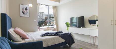 Une chambre d’hôtel moderne équipée d’un lit, d’un canapé, d’une télévision et offrant une vue sur la ville.