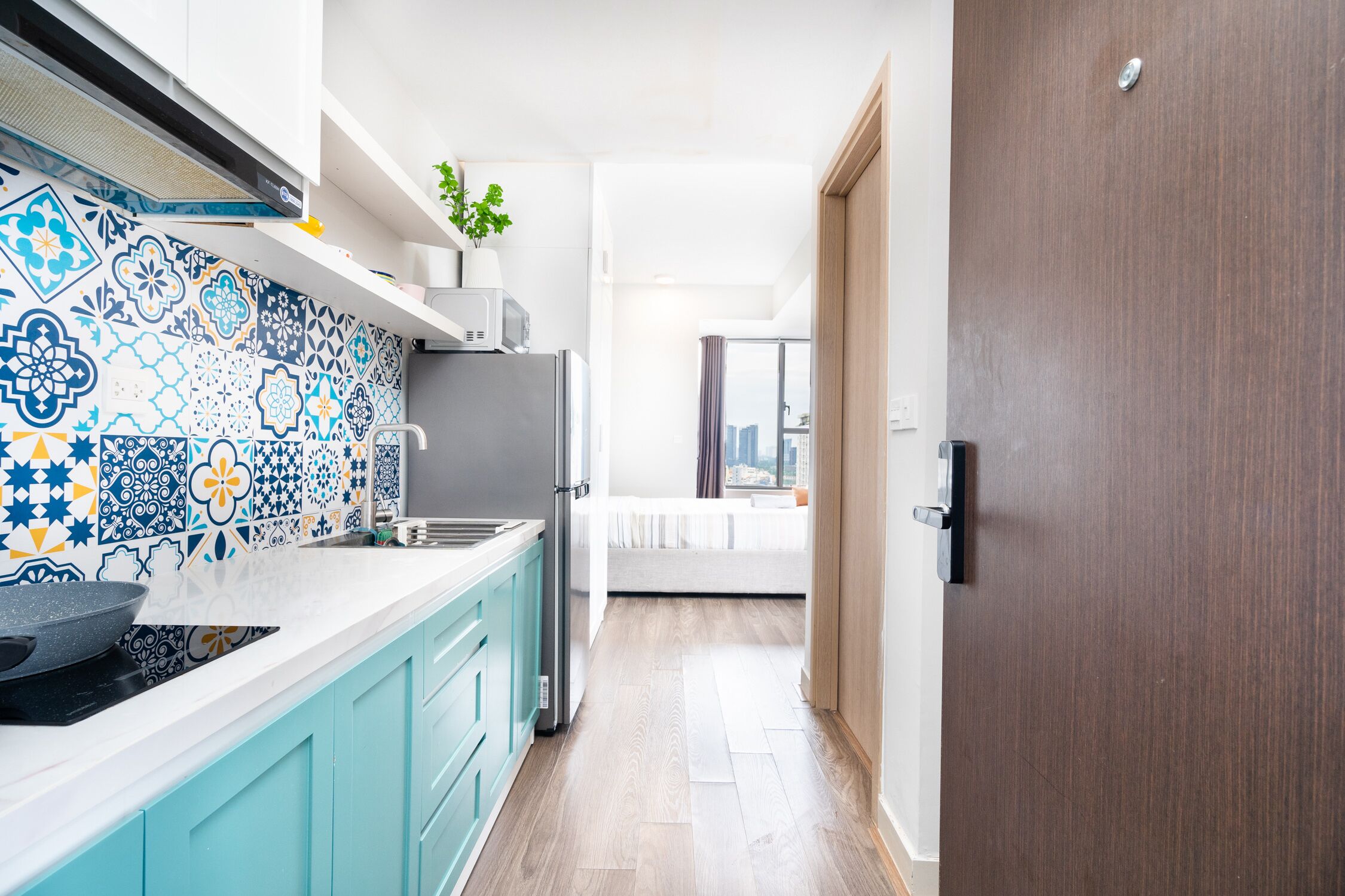 A modern kitchen with a patterned backsplash, a microwave, and a refrigerator.