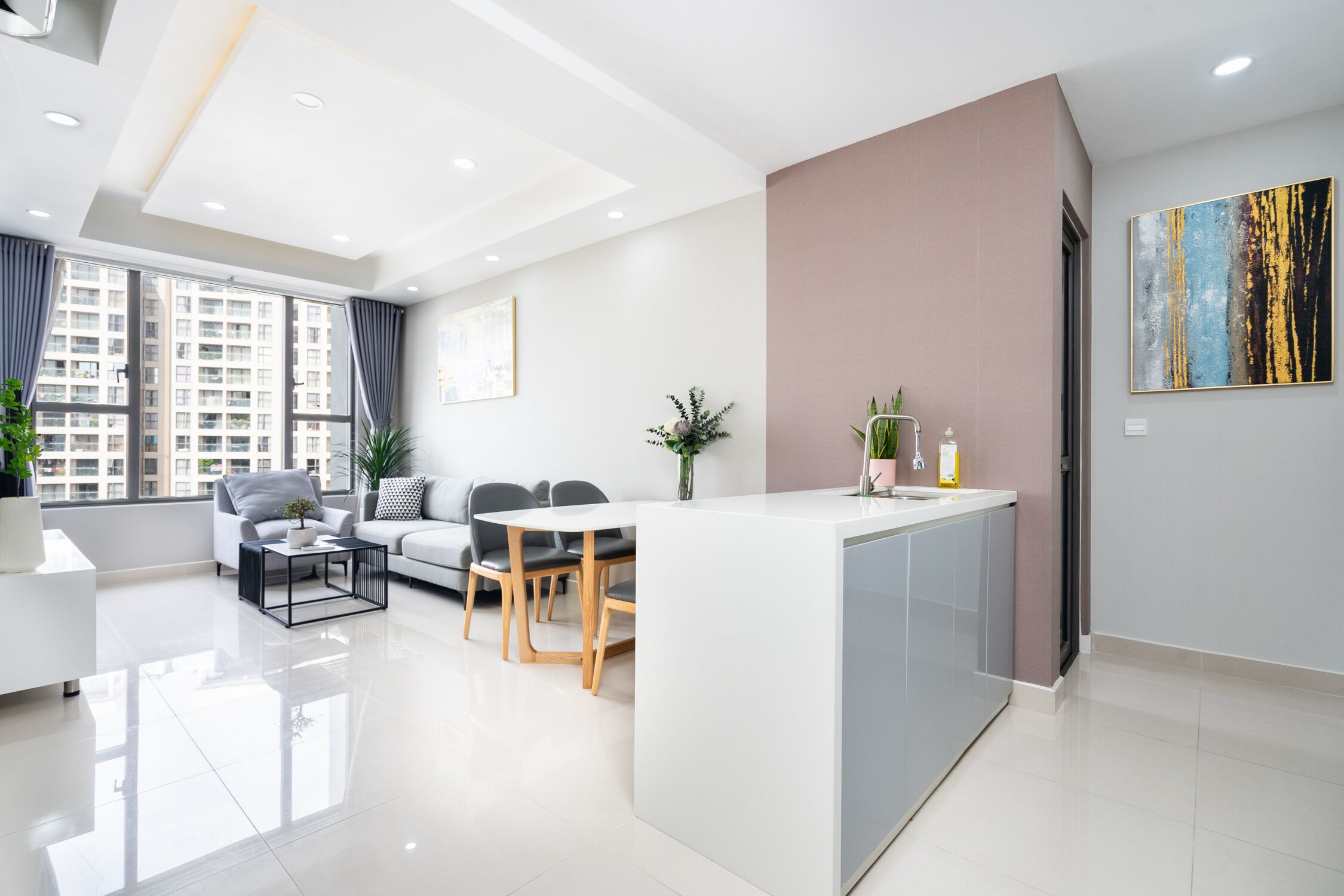 Una sala de estar moderna con comedor, una isla de cocina y ventanas amplias.