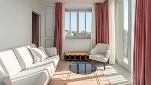 A modern living room with a sofa, armchair, and a small coffee table. - Room Mate Gran Filippo I, Roma-Fontana di Trevi (Rome)