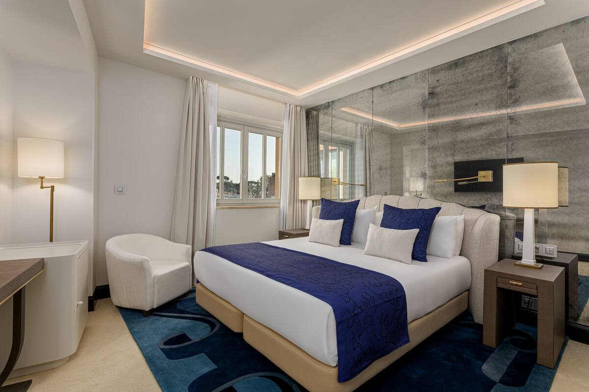 Una habitación de hotel moderna con una cama grande, un escritorio y una silla.