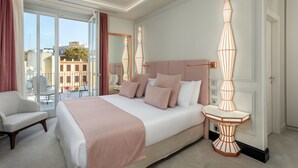 A hotel room with a large bed, a sitting area, and a view of the city through large windows. - Room Mate Gran Filippo I, Roma-Fontana di Trevi (Rome)
