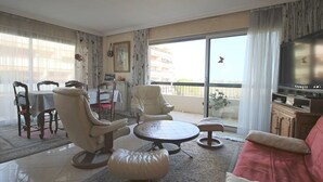 A living room with a sofa, chairs, a dining table, and a TV. - VILLENEUVE LOUBET BEACH 5MN FROM BEACHES, 2 BEDROOMS 2 BATHROOMS SEA VIEW, TENNIS  (Villeneuve-Loubet)
