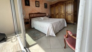 A bedroom with a bed, a wardrobe, a chair, and a door. - VILLENEUVE LOUBET BEACH 5MN FROM BEACHES, 2 BEDROOMS 2 BATHROOMS SEA VIEW, TENNIS  (Villeneuve-Loubet)