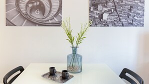 Una mesa con dos tazas y un jarrón con plantas, una escalera de caracol y un paisaje urbano.