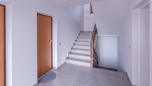 A staircase with a wooden handrail and a carpeted landing. - Buttrio Appartamento nel Verde (Buttrio)