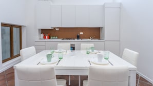 A modern kitchen with white cabinets, a built-in stove, and a window above the sink. - Ricasoli Garden Modern Apartment (Udine)