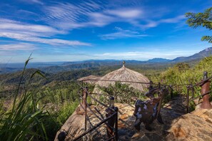 A stone staircase leading to a thatched-roof structure with a panoramic mountain view. - Dream Cliff Mountain Resort (Beragala)