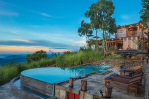 Alberca al aire libre, sombrillas en la alberca y camastros