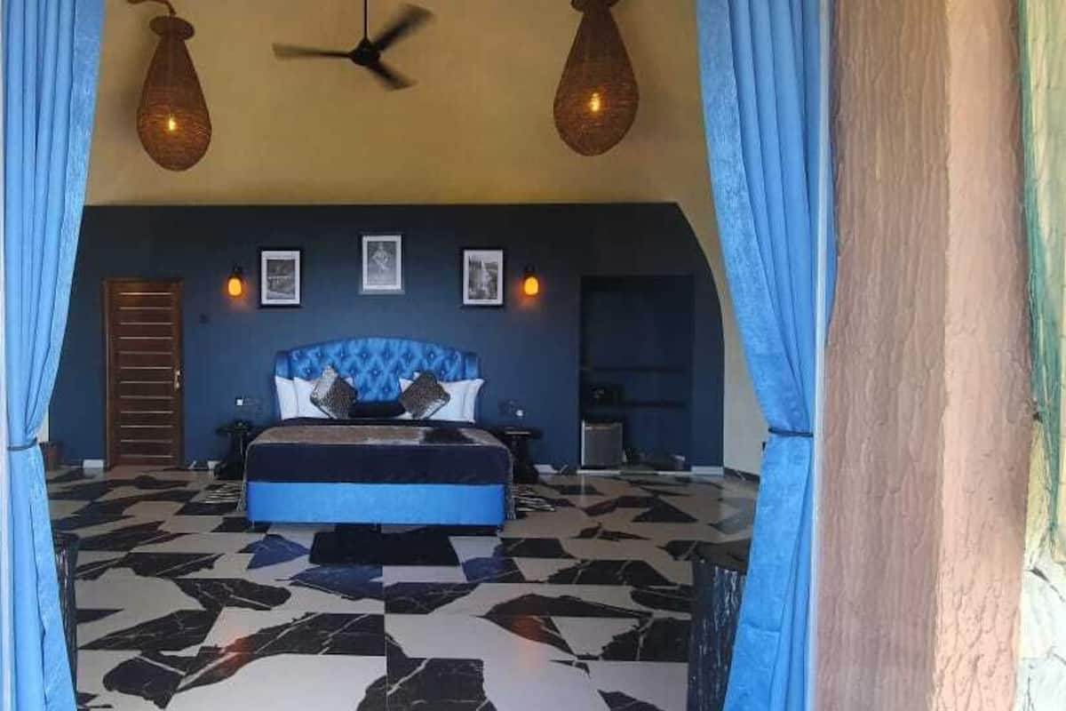 Ein Schlafzimmer mit einem Bett, einem Deckenventilator und einem gemusterten Boden.