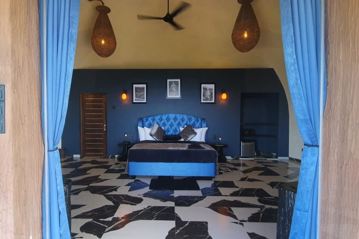 A bedroom with a bed, a ceiling fan, and a patterned floor.
