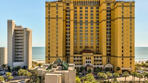 A large, yellow hotel with multiple floors and balconies, located near a beach. - Direct oceanfront pools hot tubs downtown Myrtle Beach (Myrtle Beach)