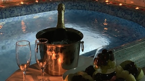 A hot tub with a champagne bottle, two glasses, and a bowl of fruit. - City Hotel Plovdiv (Plovdiv)