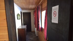 A narrow hallway with a wooden ceiling and a tiled floor. A door with a 'No Smoking' sign is visible on the right. - Central apartment, near slopes, 10 pers, WiFi (Val-d'Isère)