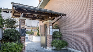 Un bâtiment en briques doté d’une entrée couverte, d’une boîte aux lettres et d’un portail.