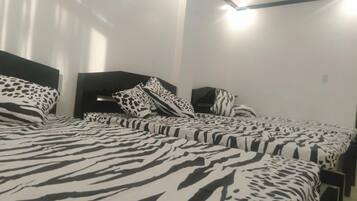 A hotel room with a zebra-patterned bedspread, a dark headboard, and a simple, clean design.