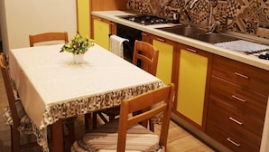 A compact kitchen with a dining table, chairs, and a patterned backsplash. - Dimora Ruggiero (Naples)