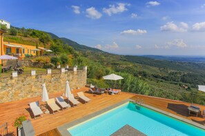 Una piscina al aire libre de temporada, sombrillas, tumbonas