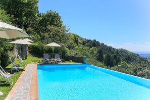 Una piscina al aire libre de temporada, sombrillas