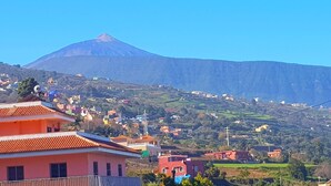 Une ville aux bâtiments aux couleurs vives, avec une montagne imposante en arrière-plan.