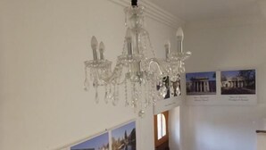 A multi-level interior with a chandelier, photographs on the walls, and a staircase. - Hotel Barrio Yungay (Santiago)