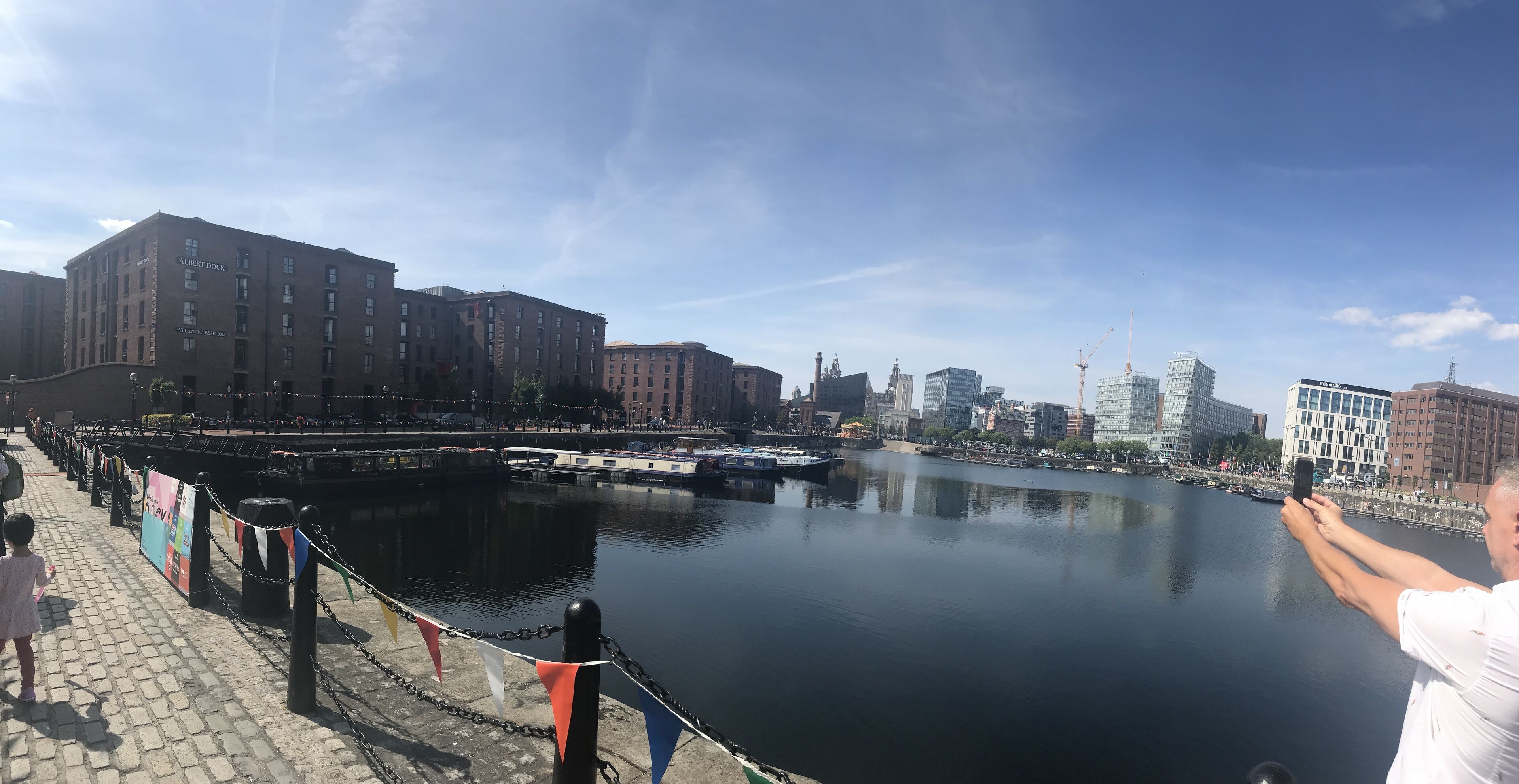 A waterfront view with buildings, a dock, and a calm river.