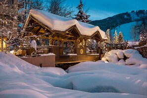 A snow-covered wooden structure with a sign indicating it is a hotel. - Cozy & Central Arrowhead Ge Townhome 2 Bedroom Condo by RedAwning (Edwards)
